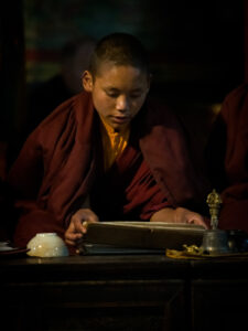 Young monk praying at Chiwong Monastery in Solu the lower Everest region of Nepal