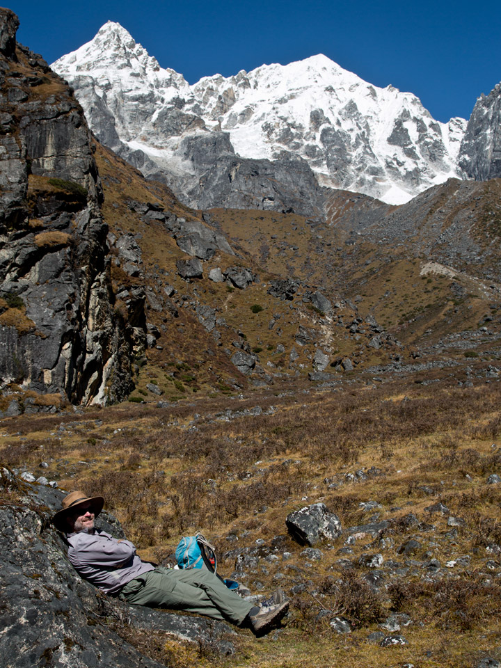 Trekker taking a rest on the way to Cheram on the Kanchenjunga south BC trek. Boktah in the background.