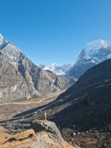 Trekker enjoying the view of the Rolwaling glacier, Chobuje 6686m and Dragnag Ri 6801m from the trail to Yarlung base camp in Rolwaling, Nepal