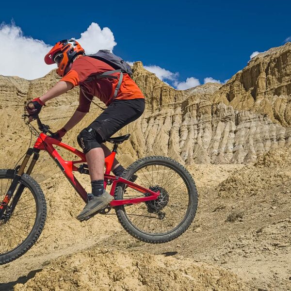Rider jumping in front of the cave cliffs in the Samdzong valley, Upper Mustang, Nepal